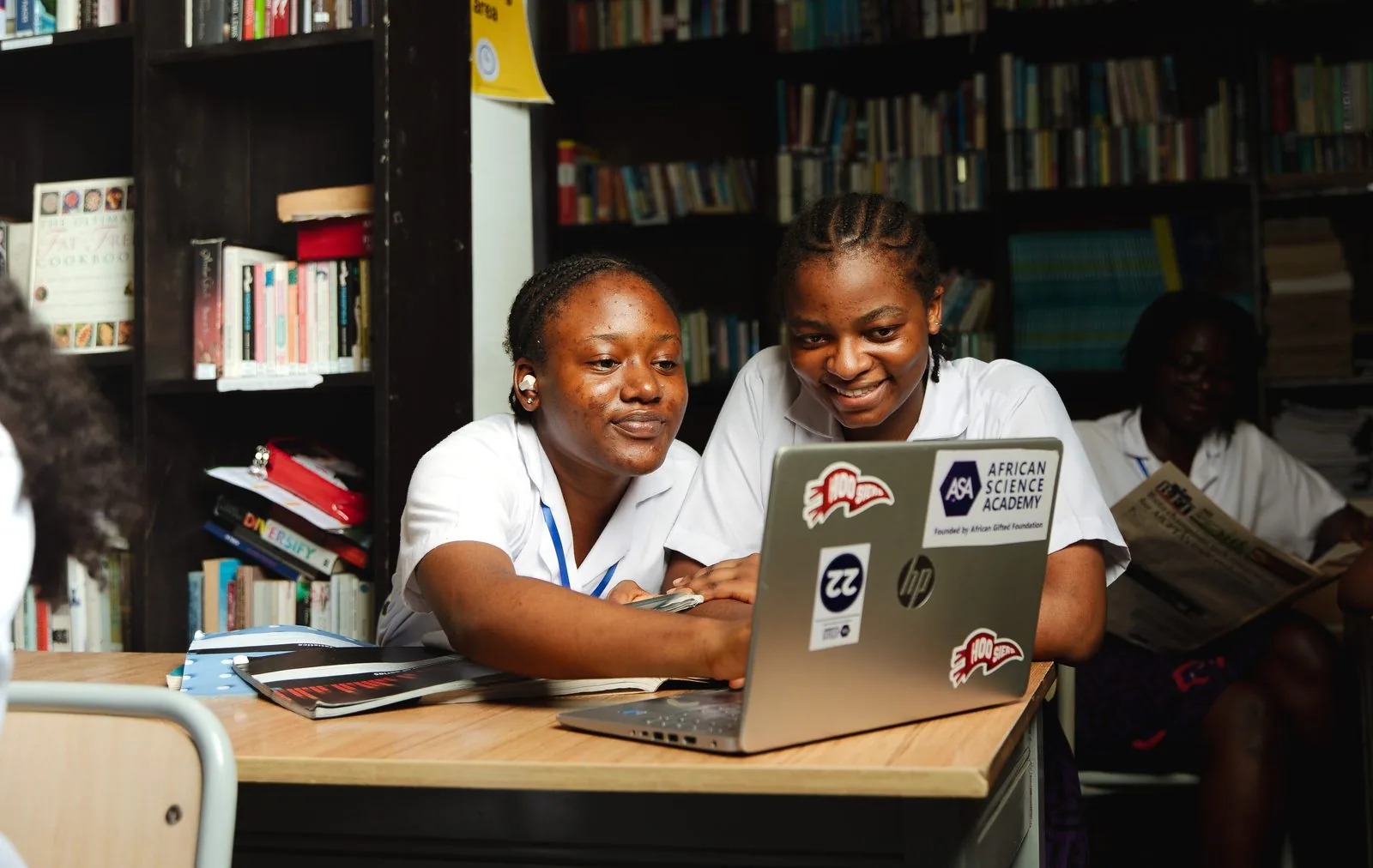 Two ASA students studying together on a laptop in the library